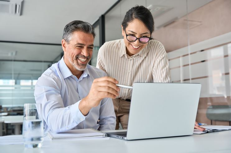 Imagen de pareja sonriente mirando un computador  Imagen de pareja sonriente mirando un computador